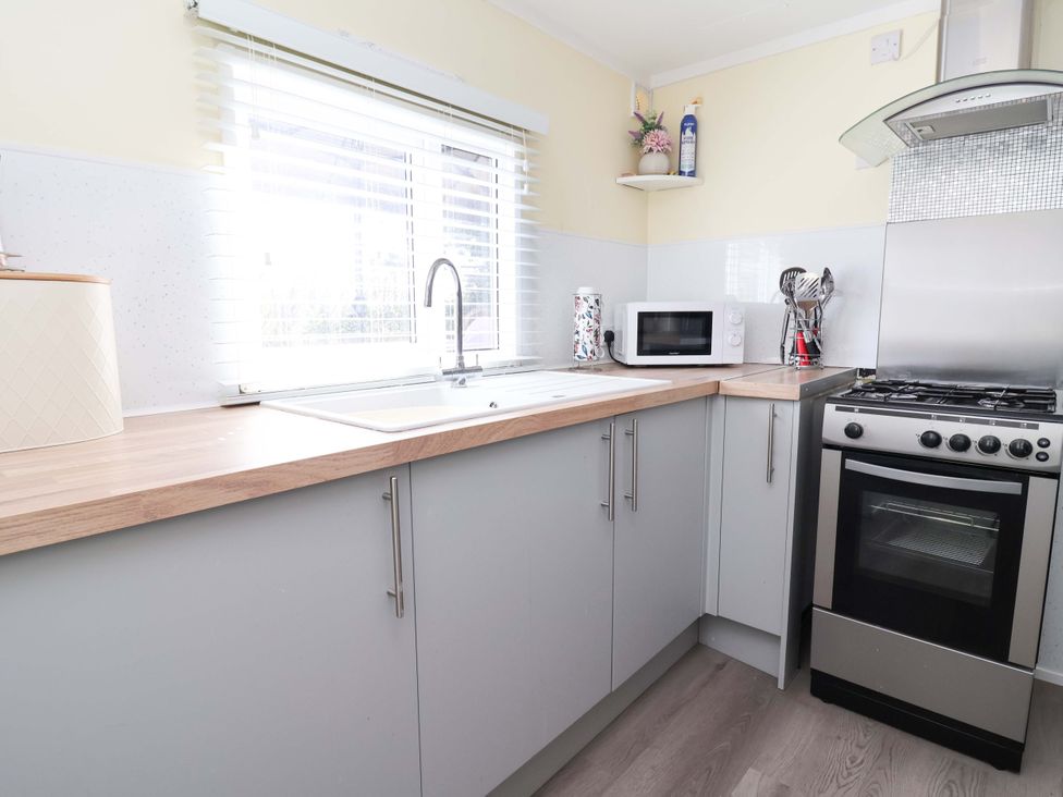 A kitchen with a sink and microwave at Grosvenor 10 in Llanarmon-Yn-Ial