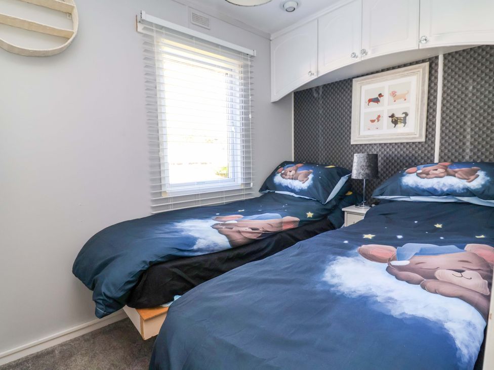 A bedroom with two beds and a window at Grosvenor 10 in Llanarmon-Yn-Ial