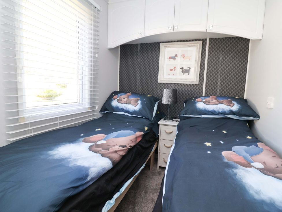 A bedroom with twin beds and a window at Grosvenor 10 in Llanarmon-Yn-Ial