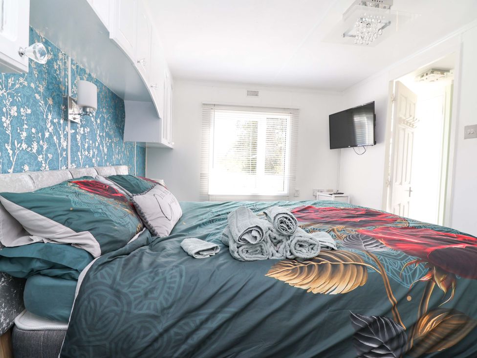 A bedroom with a bed and towels on it at Grosvenor 10 Llanarmon-Yn-Ial