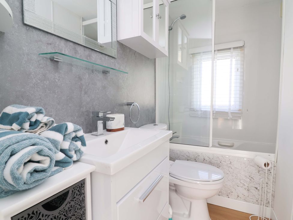 A bathroom with a wash basin and shower at Grosvenor 10 in Llanarmon-Yn-Ial