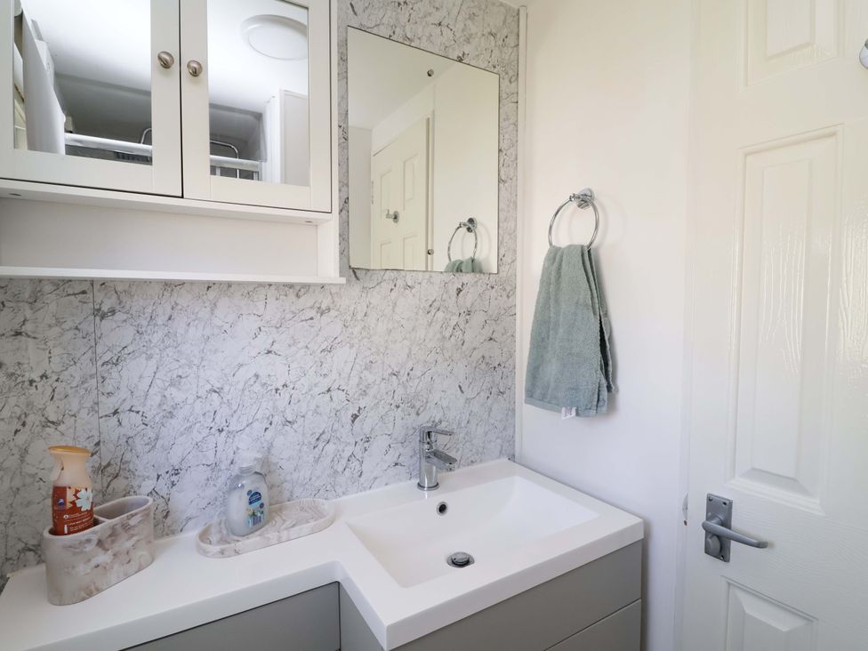 A bathroom with a sink and mirror at Grosvenor 10 in Llanarmon-Yn-Ial