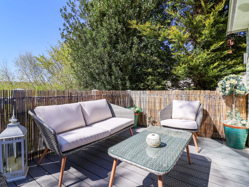 An outdoor seating area with a sofa and coffee table at Grosvenor 10 in Llanarmon-Yn-Ial