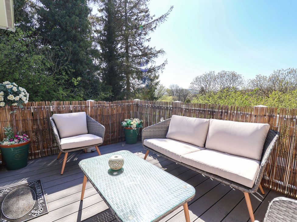 An outdoor terrace with a sofa and table at Grosvenor 10 in Llanarmon-Yn-Ial