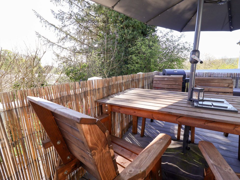 An outdoor seating area with a table and chairs at Grosvenor 10 in Llanarmon-Yn-Ial