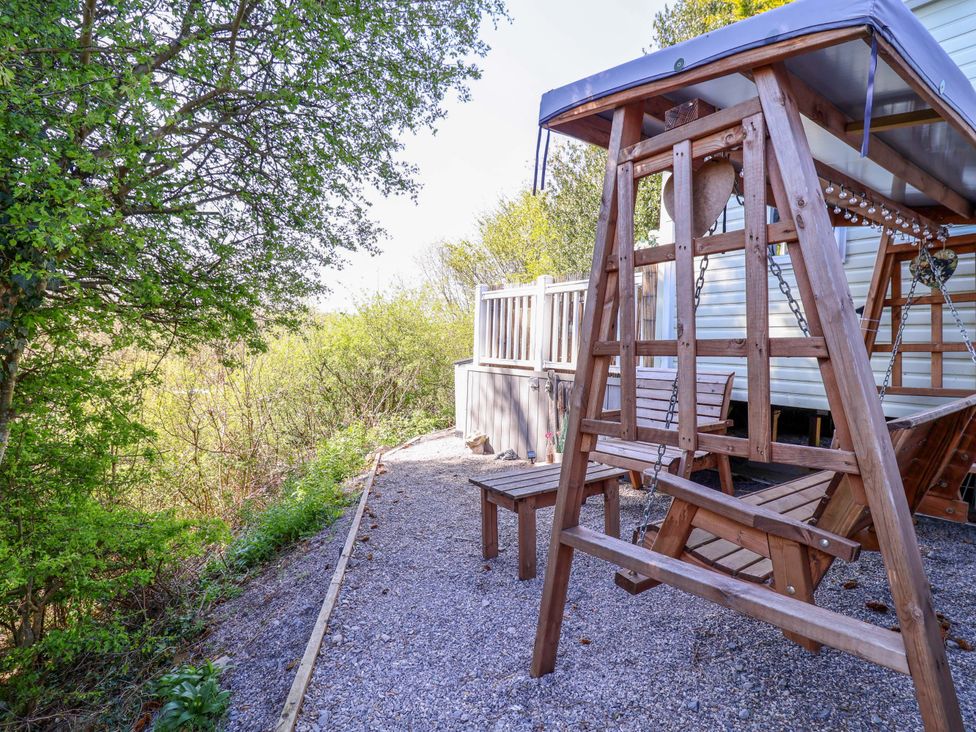 An outdoor area with a swing and bench at Grosvenor 10 in Llanarmon-Yn-Ial
