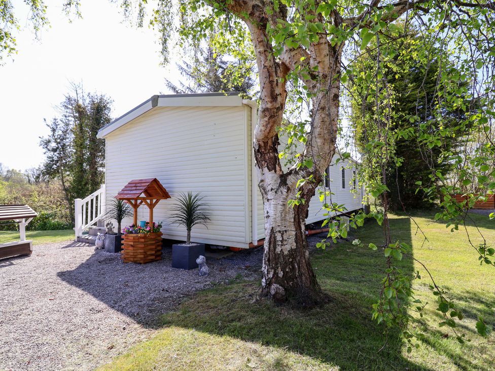 A outdoor view of a mobile home surrounded by a garden at Grosvenor 10 Llanarmon-Yn-Ial