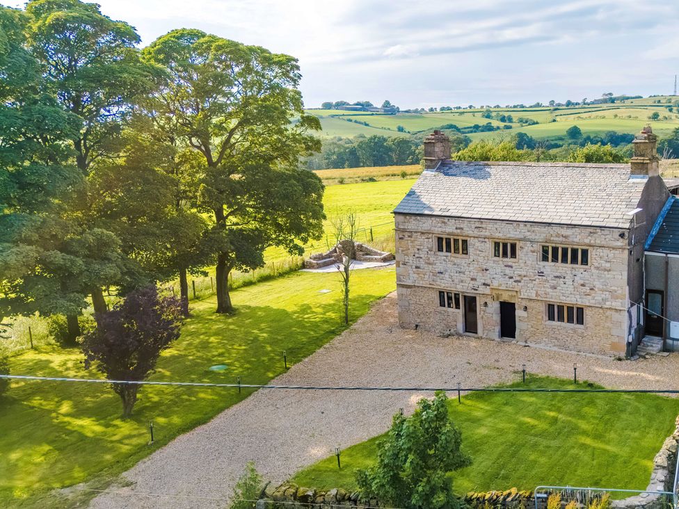 A house with trees and a gravel driveway at Landskill Farm Preston