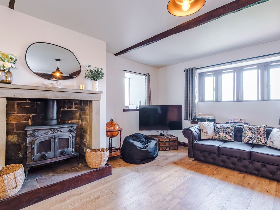 A living room with a fireplace and television at Landskill Farm in Preston