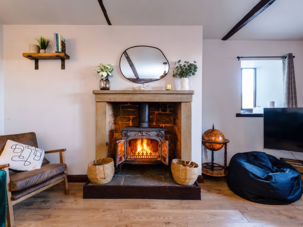 A living room with a fireplace and a television at Landskill Farm in Preston