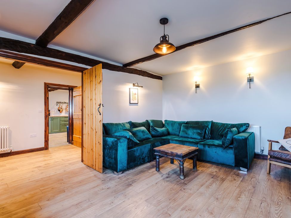 A living room with a green sofa and wooden coffee table at Landskill Farm in Preston