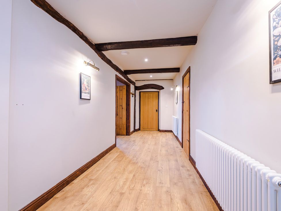 A hallway with wooden door and light fixtures at Landskill Farm in Preston