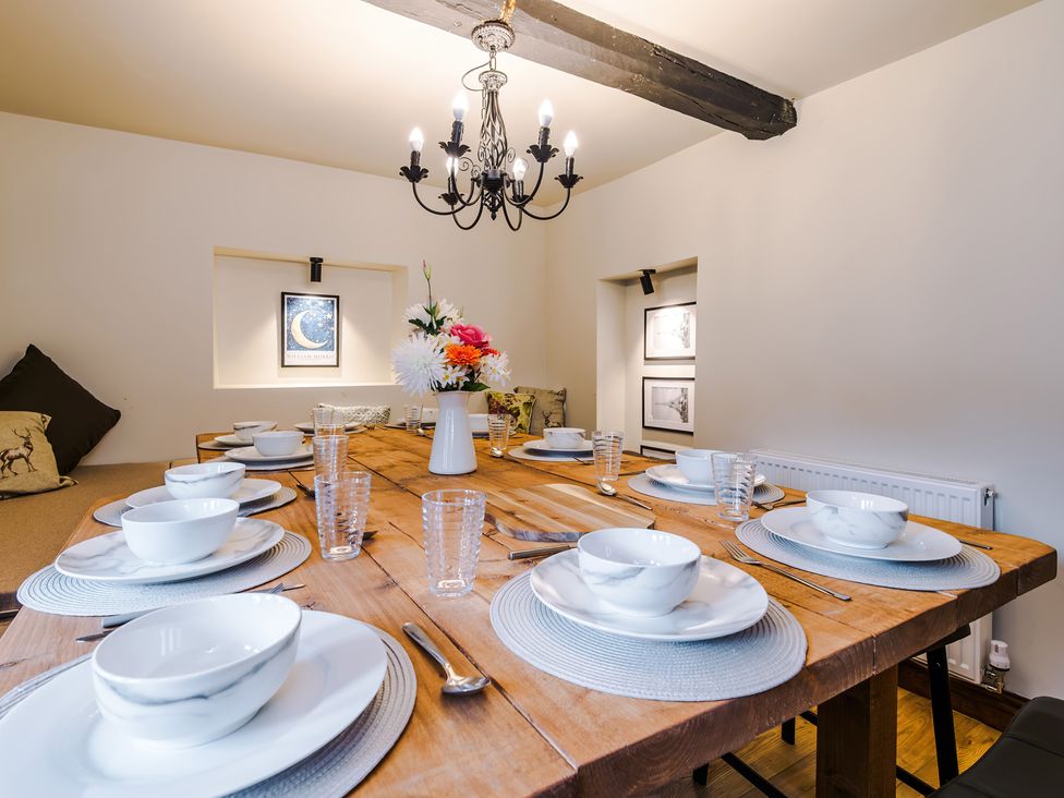 A dining room with a wooden table set for a meal at Landskill Farm in Preston