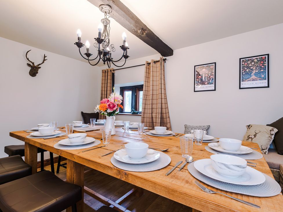 A dining room with a wooden table set for dinner at Landskill Farm in Preston