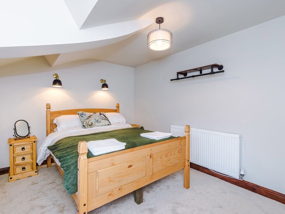 A bedroom with a bed and bedside table at Landskill Farm in Preston