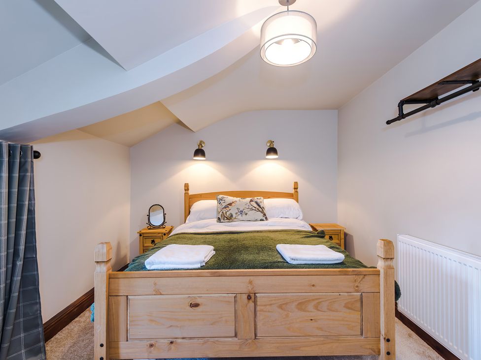 A bedroom with a bed and nightstand at Landskill Farm in Preston