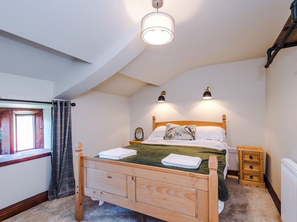 A bedroom with a bed and nightstand at Landskill Farm Preston