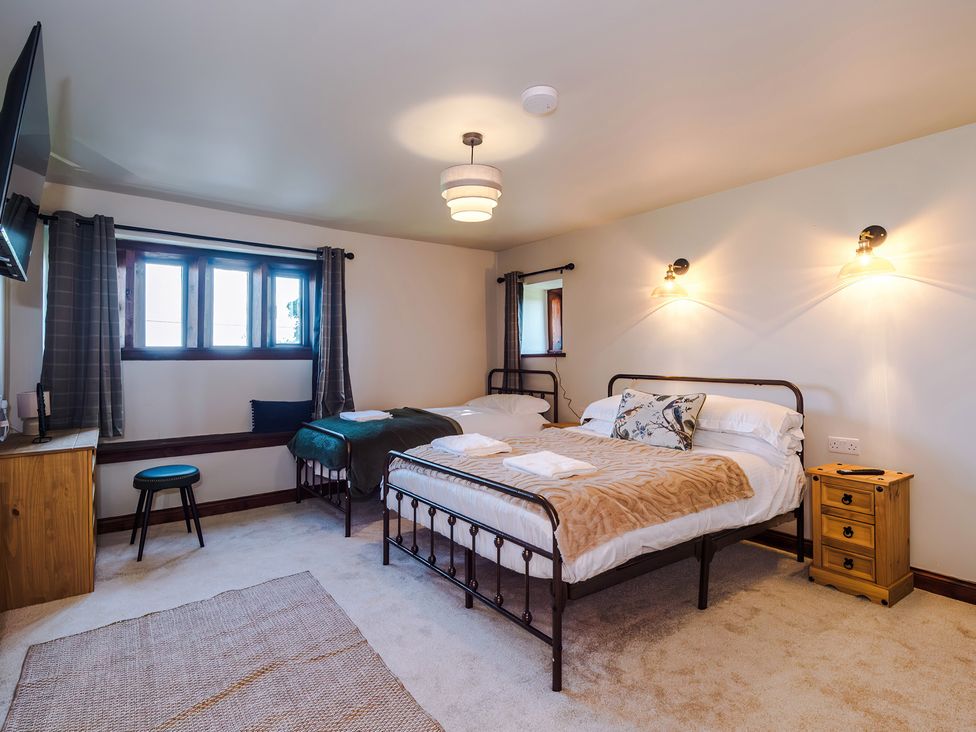 A bedroom with two beds and a television at Landskill Farm in Preston