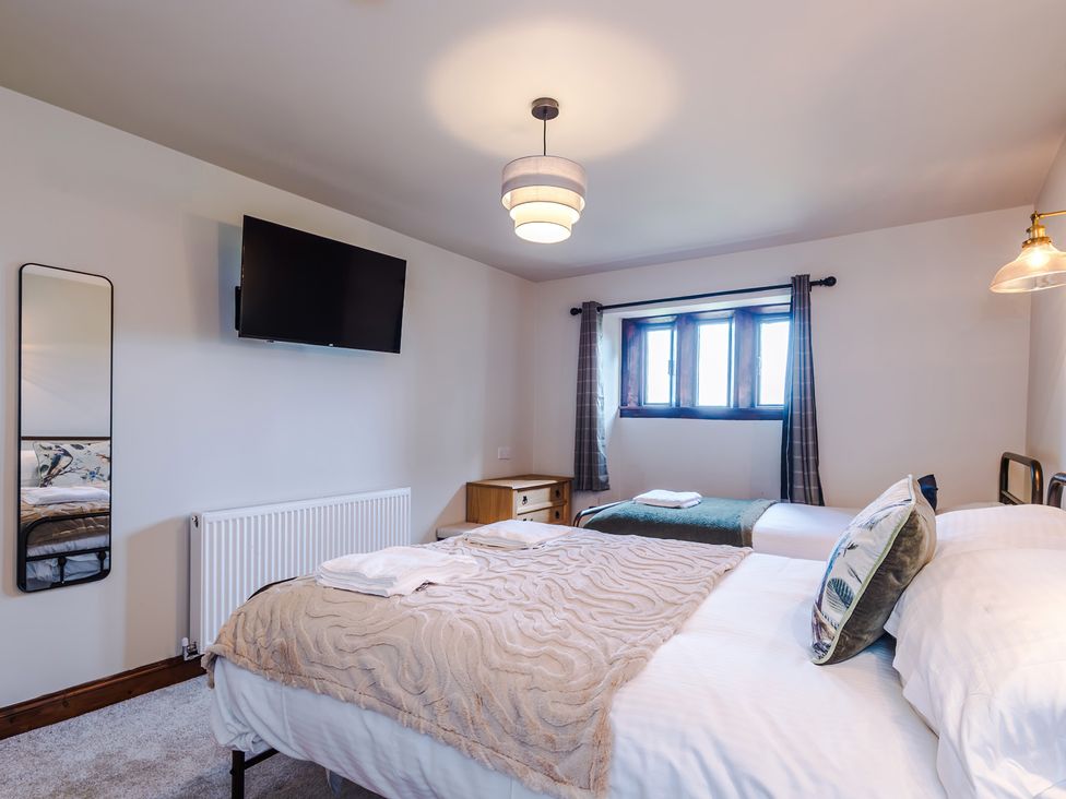 A bedroom with two beds and a television at Landskill Farm in Preston