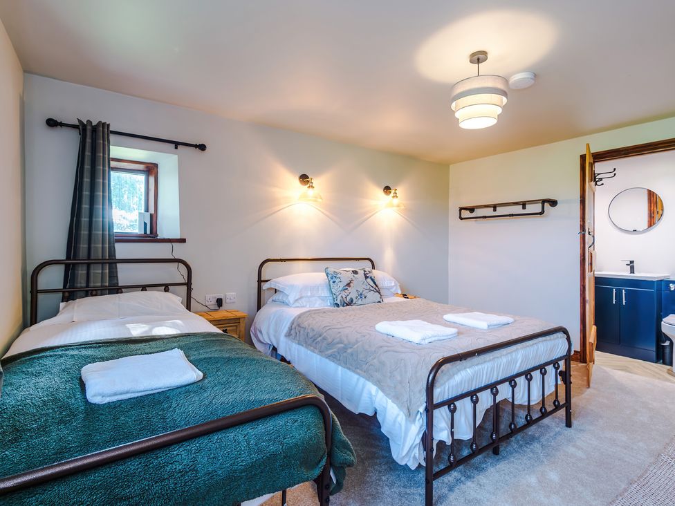 A bedroom with two beds and an ensuite bathroom at Landskill Farm in Preston