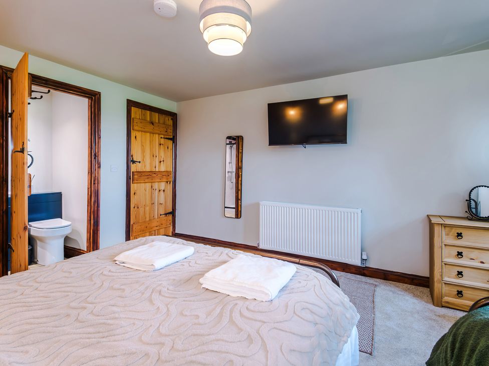 A bedroom with a bed and TV at Landskill Farm, Preston