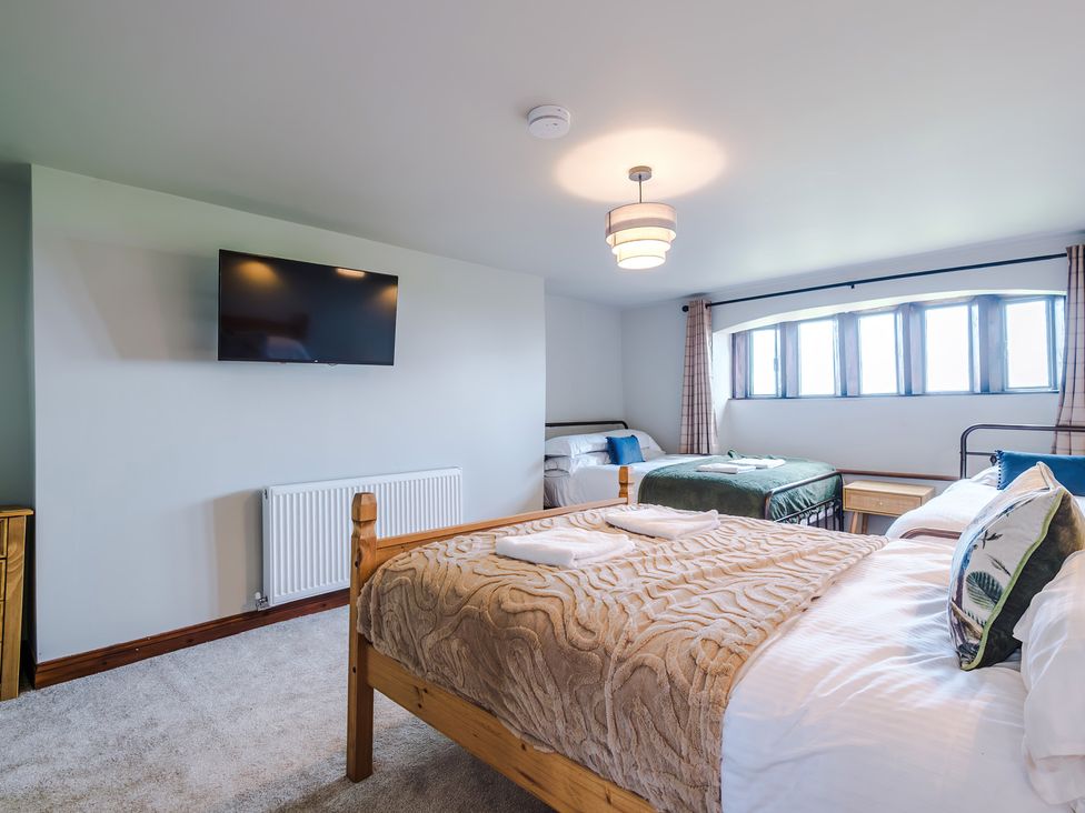 A bedroom with two beds and a TV at Landskill Farm Preston