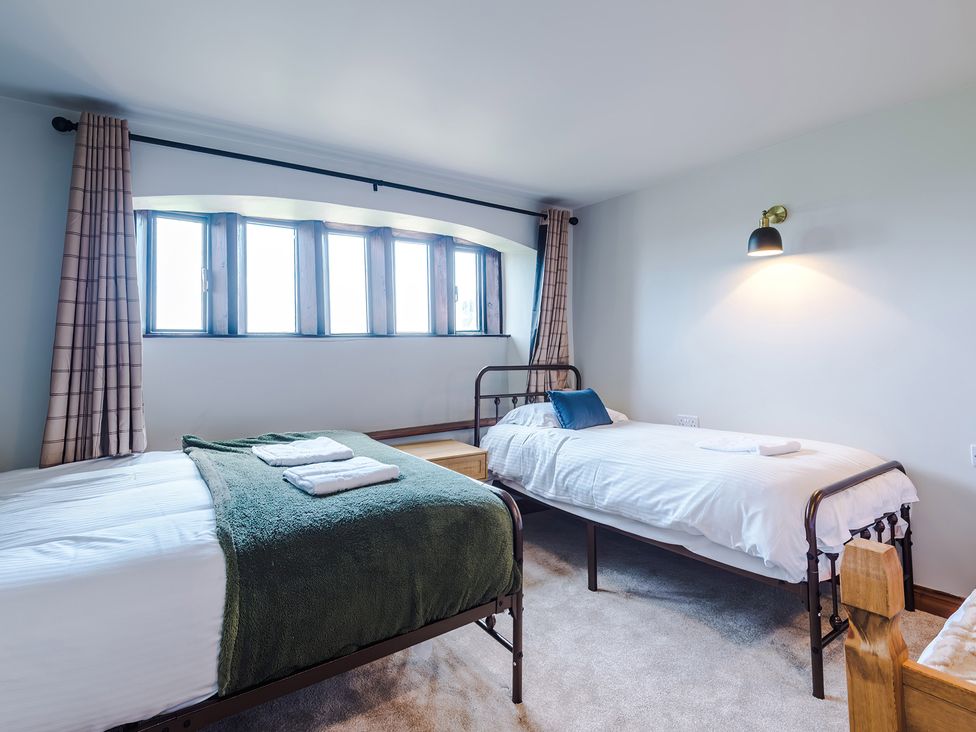 A bedroom with two beds and windows at Landskill Farm in Preston