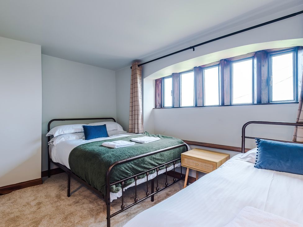 A bedroom with two beds and a window at Landskill Farm in Preston