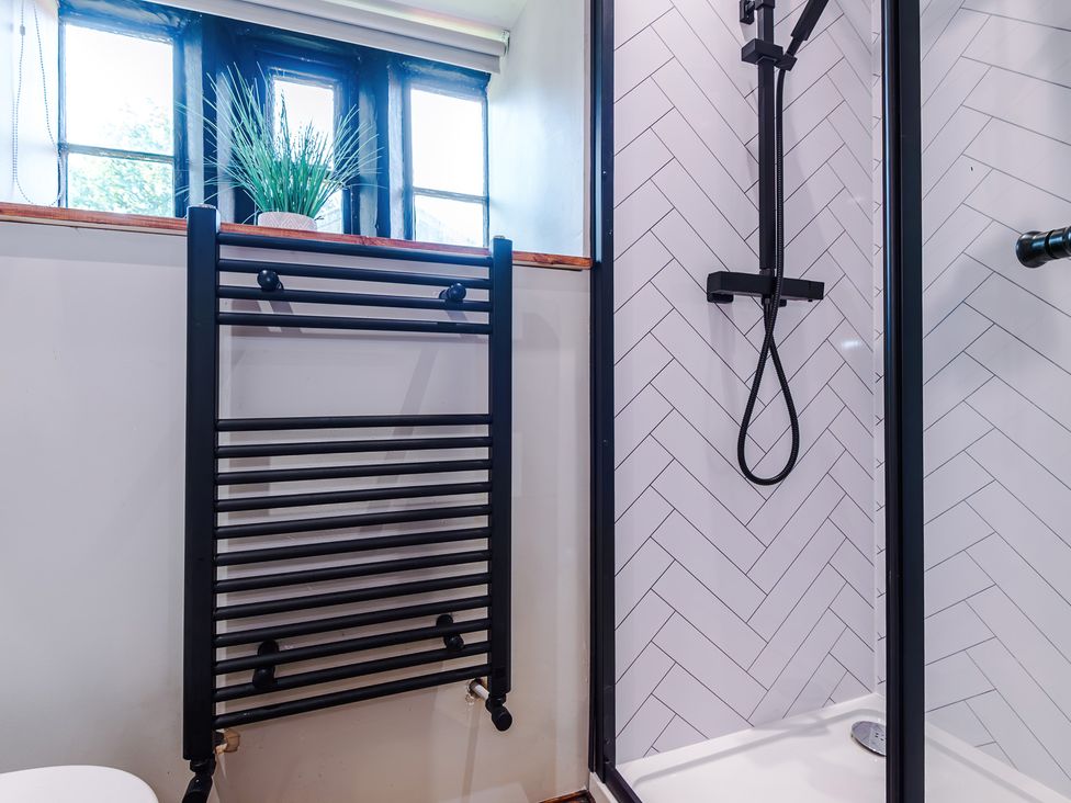 A bathroom with a shower and towel rail at Landskill Farm Preston