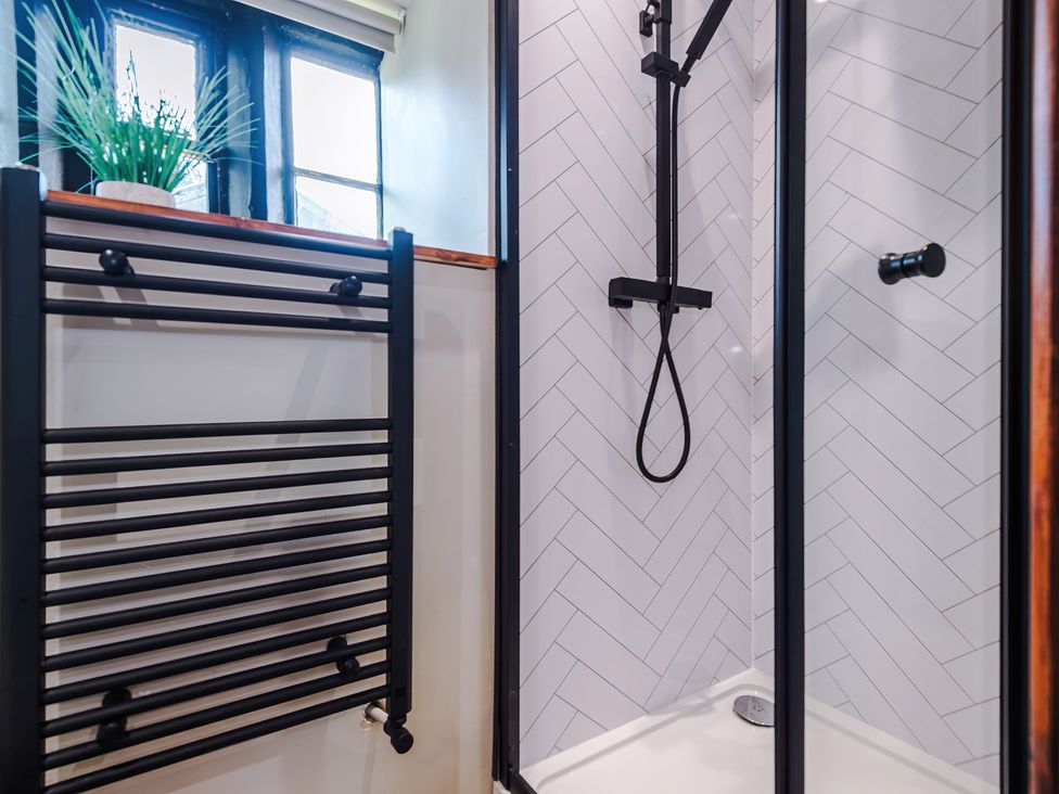 A bathroom with a shower and towel rack at Landskill Farm in Preston