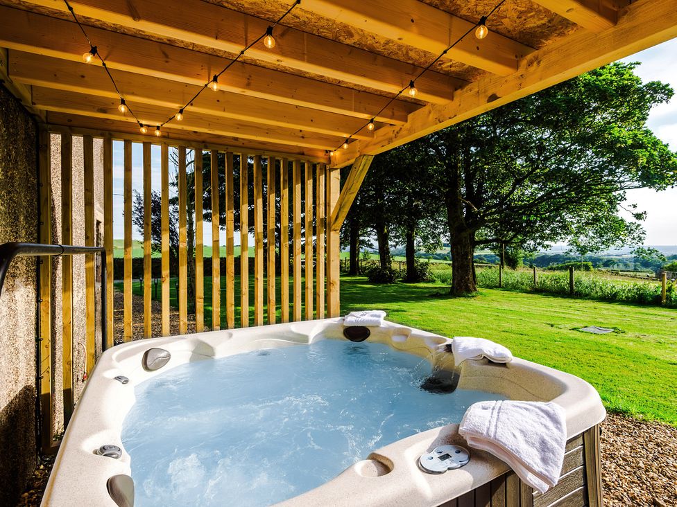 A hot tub in an outdoor area with wooden beams at Landskill Farm Preston