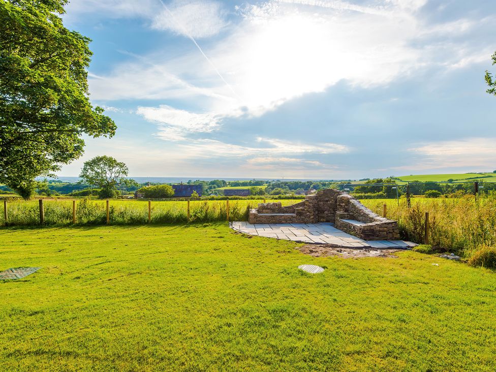 An outdoor area with a stone seating area and grass at Landskill Farm in Preston