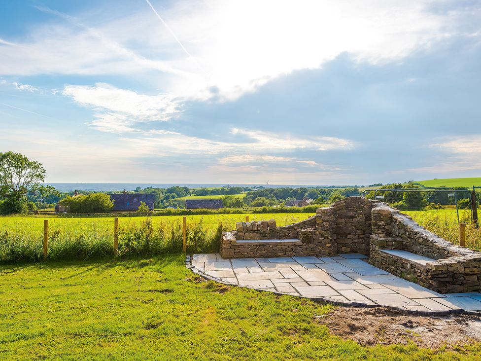 A garden with stone seating and a view at Landskill Farm in Preston