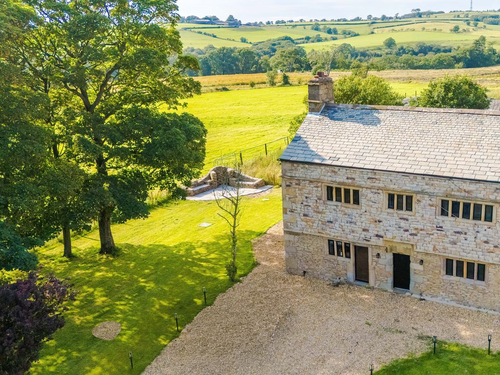 An exterior view of a house with trees and a garden at Landskill Farm in Preston