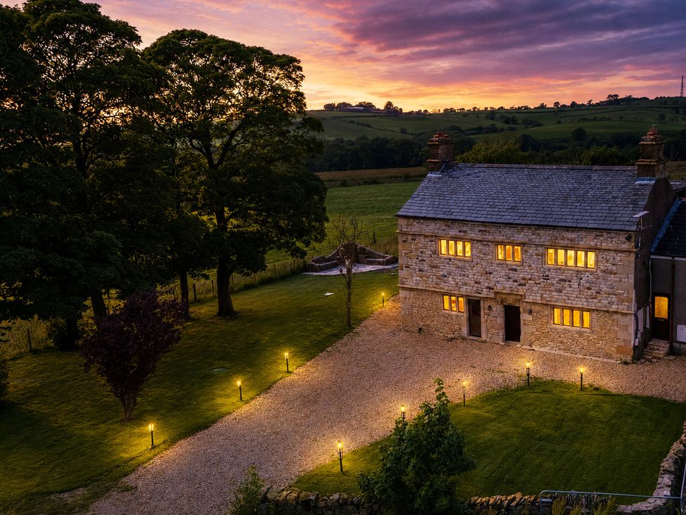 An exterior view of a house with trees and a gravel path at Landskill Farm in Preston