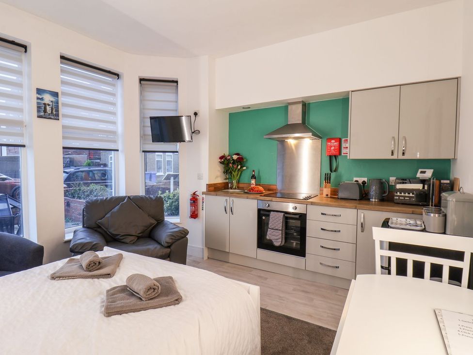 A studio apartment with a bed and kitchen area at Frankie’s Seaview 1 in Bridlington