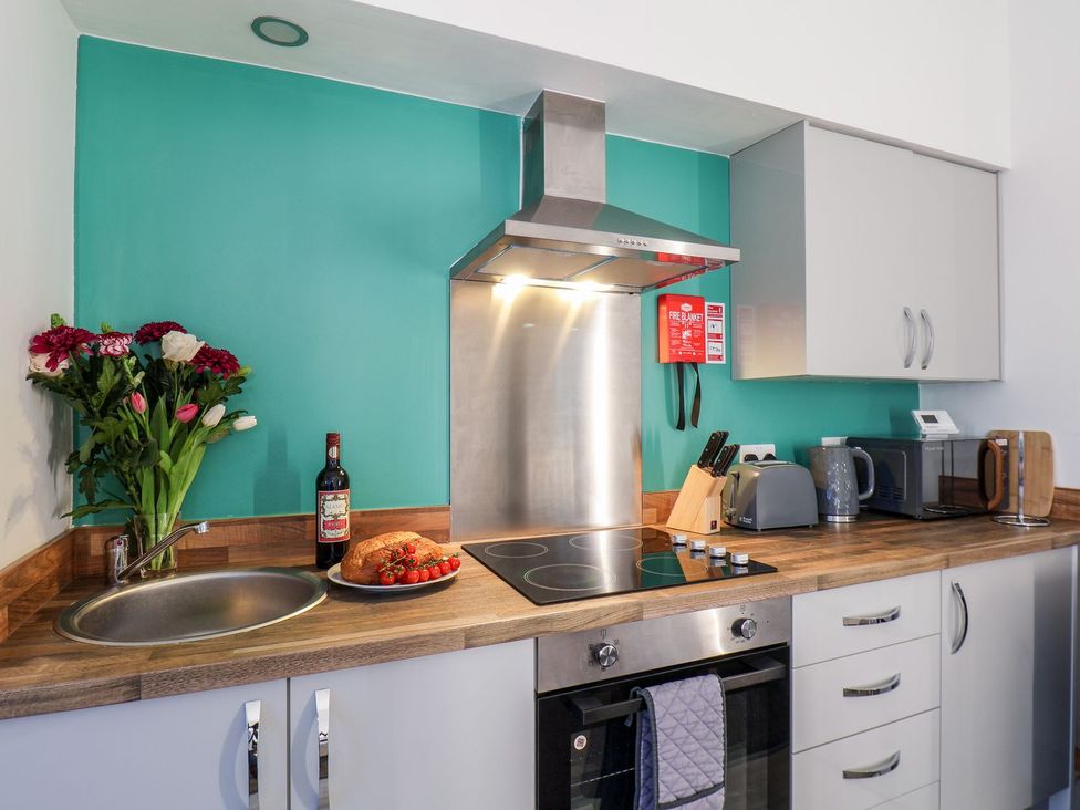 A kitchen with flowers and a plate of food at Frankie’s Seaview 1 in Bridlington