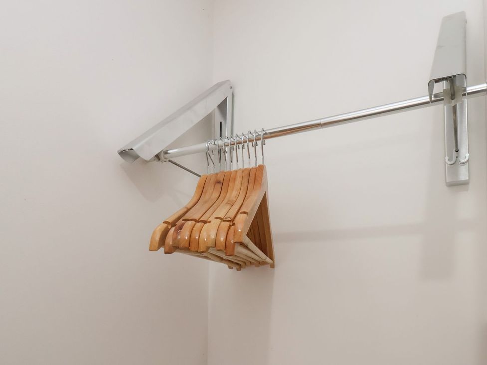 A closet with wooden hangers on a metal rod at Frankie’s Seaview 1 in Bridlington