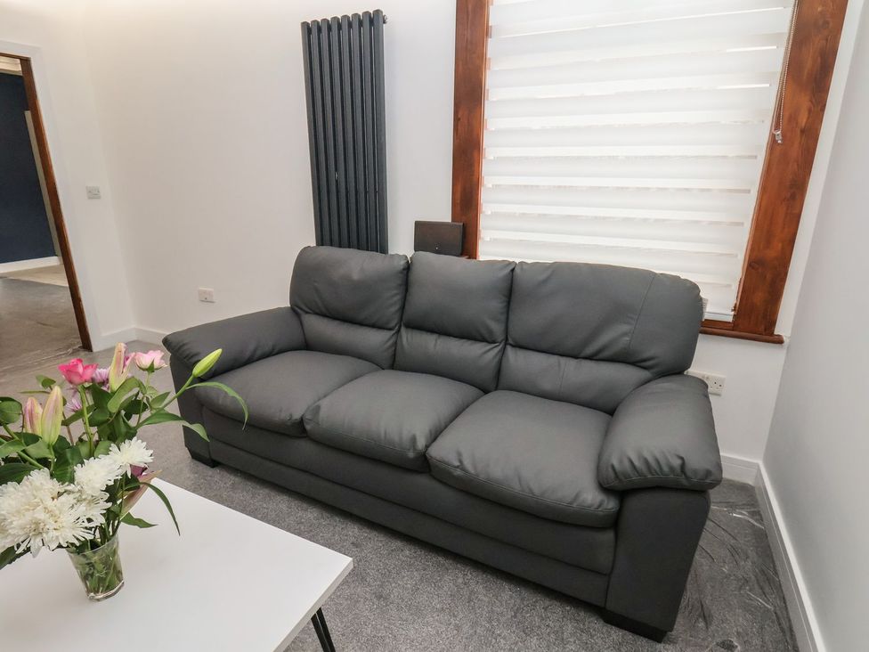 A living room with a sofa and a flower arrangement at Frankie’s Seaview 2 in Bridlington
