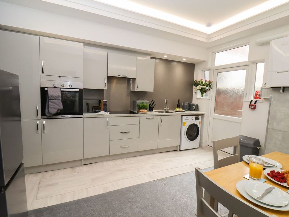 A kitchen with appliances and dining table at Frankie’s Seaview 2 in Bridlington