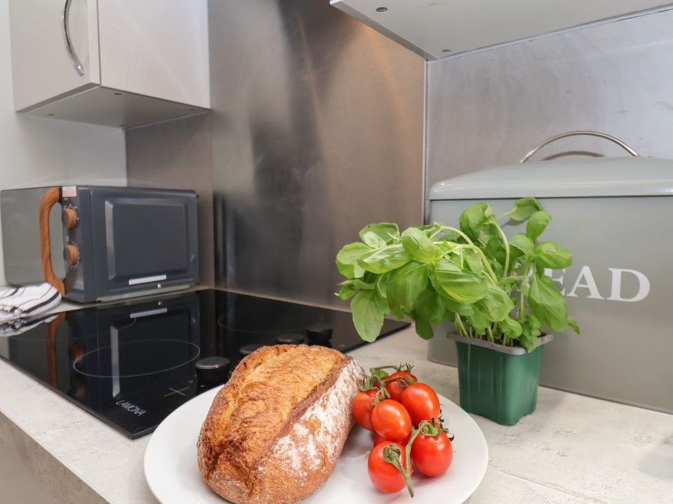A kitchen with bread, tomatoes, and basil at Frankie’s Seaview 2, Bridlington