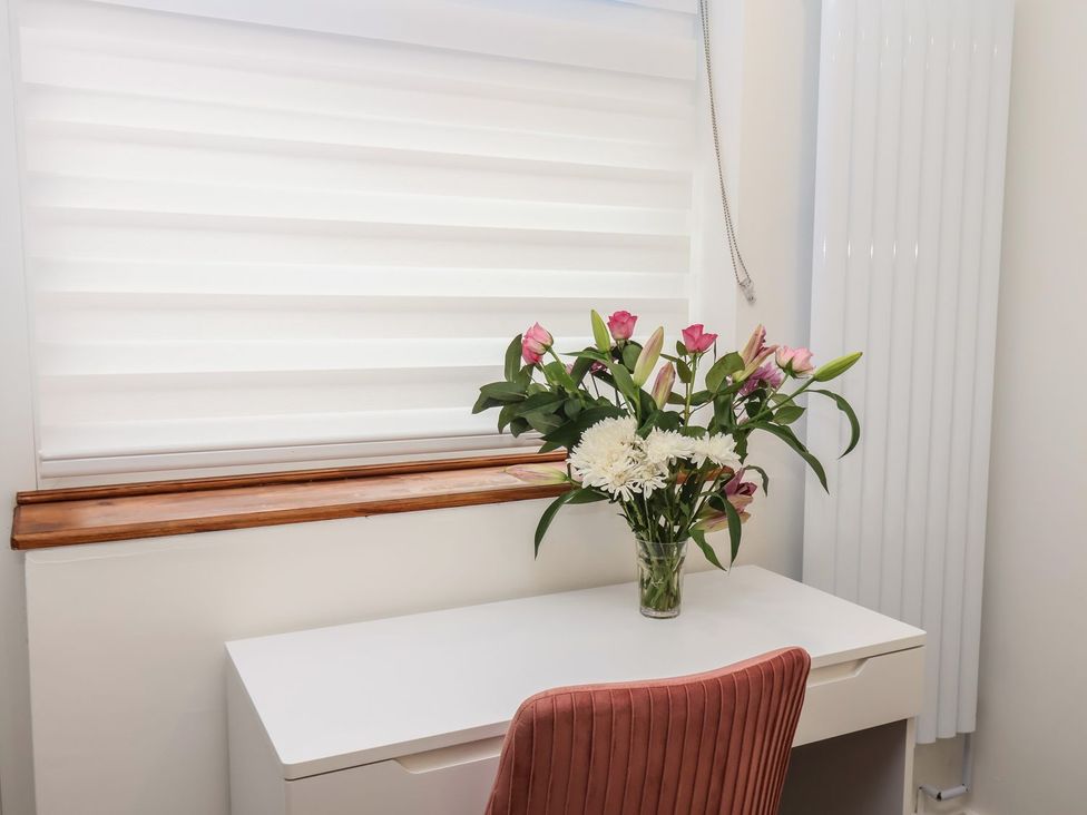 A home office with flowers on the desk at Frankie’s Seaview 2 in Bridlington