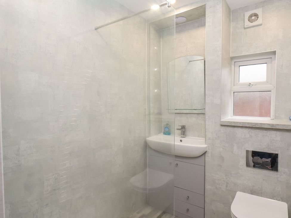 A bathroom with a shower, sink, toilet and window at Frankie’s Seaview 2 Bridlington