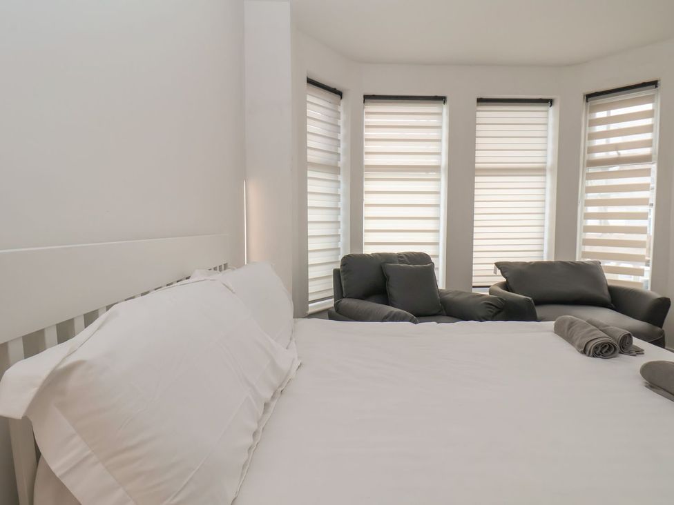 A bedroom with a bed and chairs at Frankie’s Seaview 4 in Bridlington