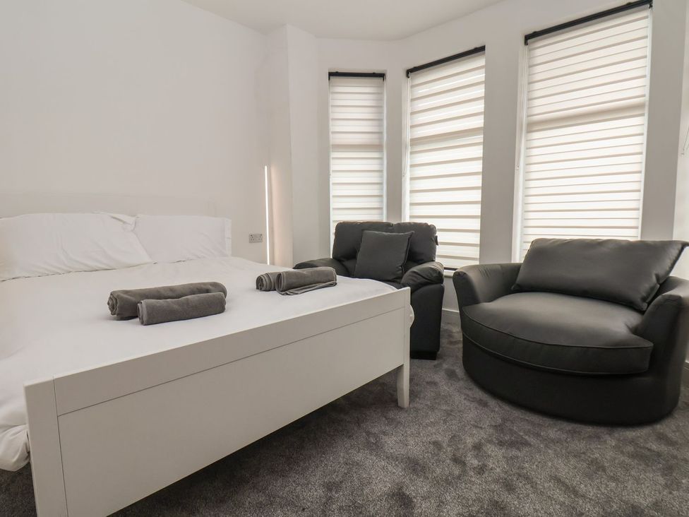 A bedroom with a bed and armchair at Frankie’s Seaview 4 in Bridlington