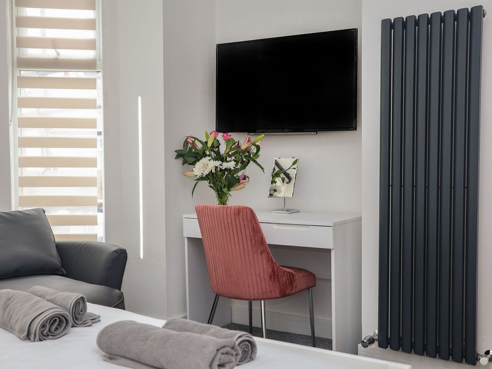 A bedroom with a desk and television at Frankie’s Seaview 4 in Bridlington