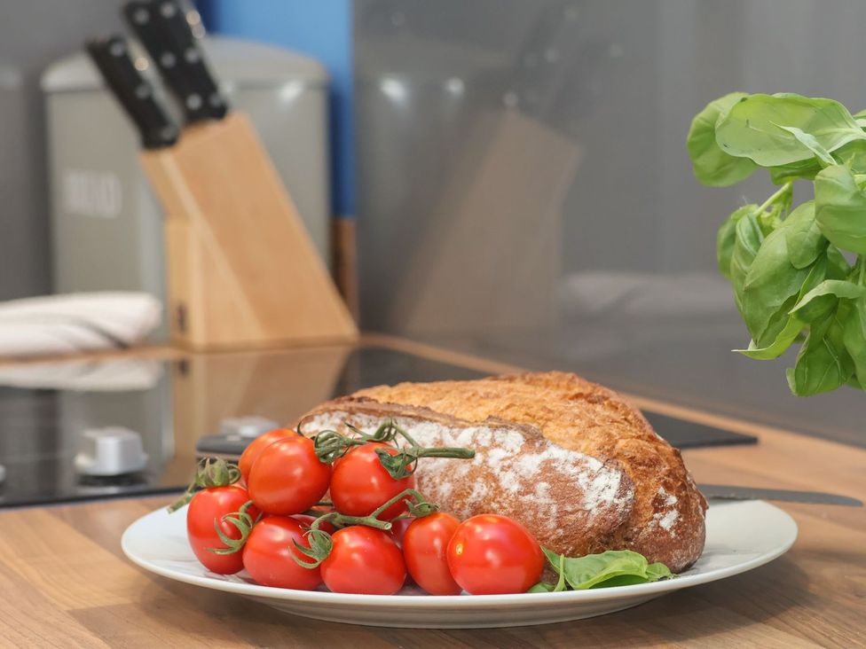 A plate with bread and tomatoes on a kitchen counter at Frankie’s Seaview 4 in Bridlington