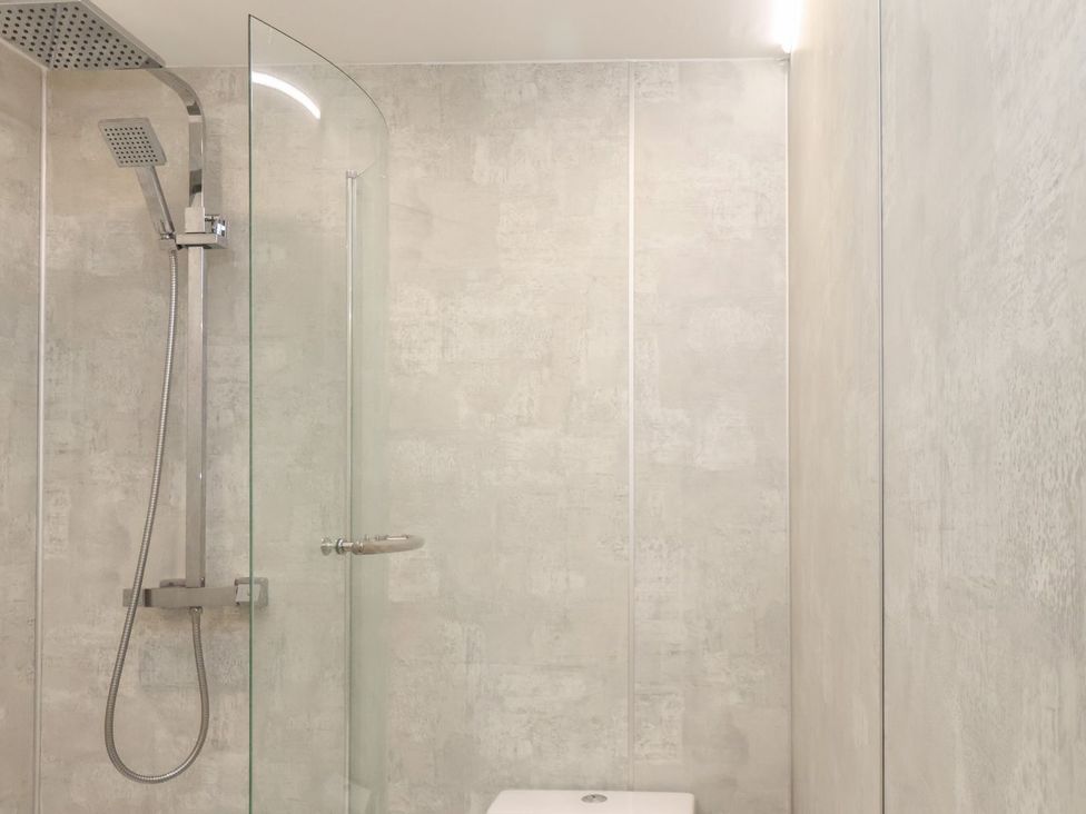 A bathroom with a shower and glass door at Frankie’s Seaview 4 in Bridlington