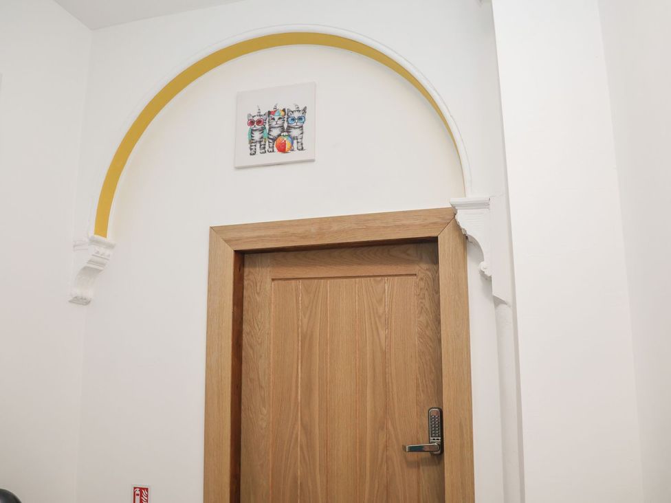 A door with an arch above it and a painting on the wall at Frankie’s Seaview 4 in Bridlington