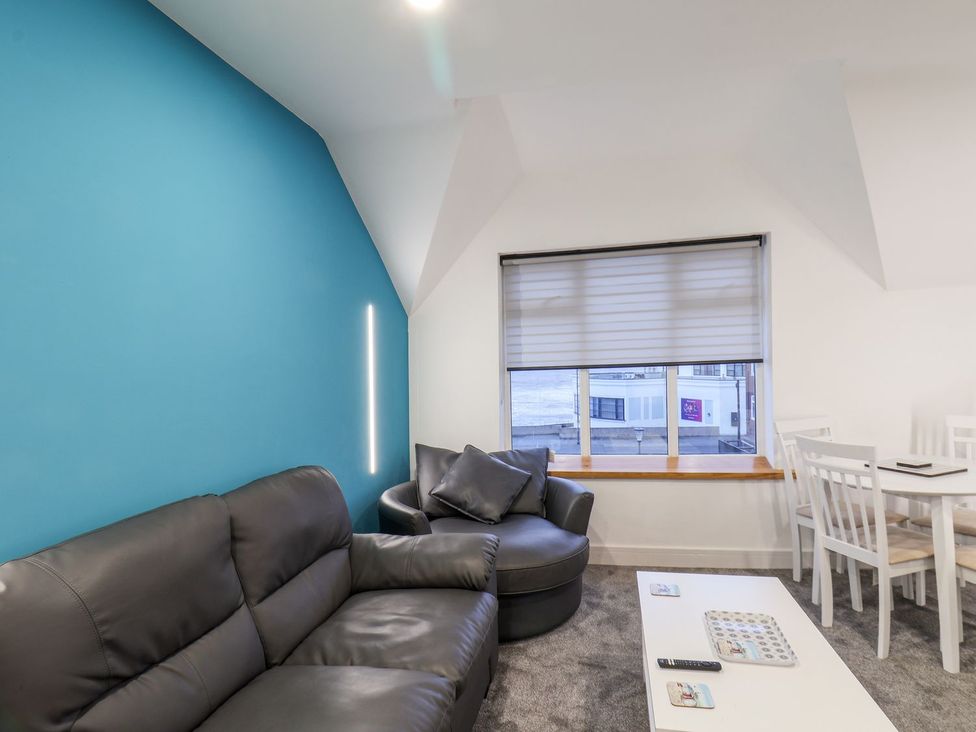 A living room with a sofa and table at Frankie’s Seaview 5 in Bridlington